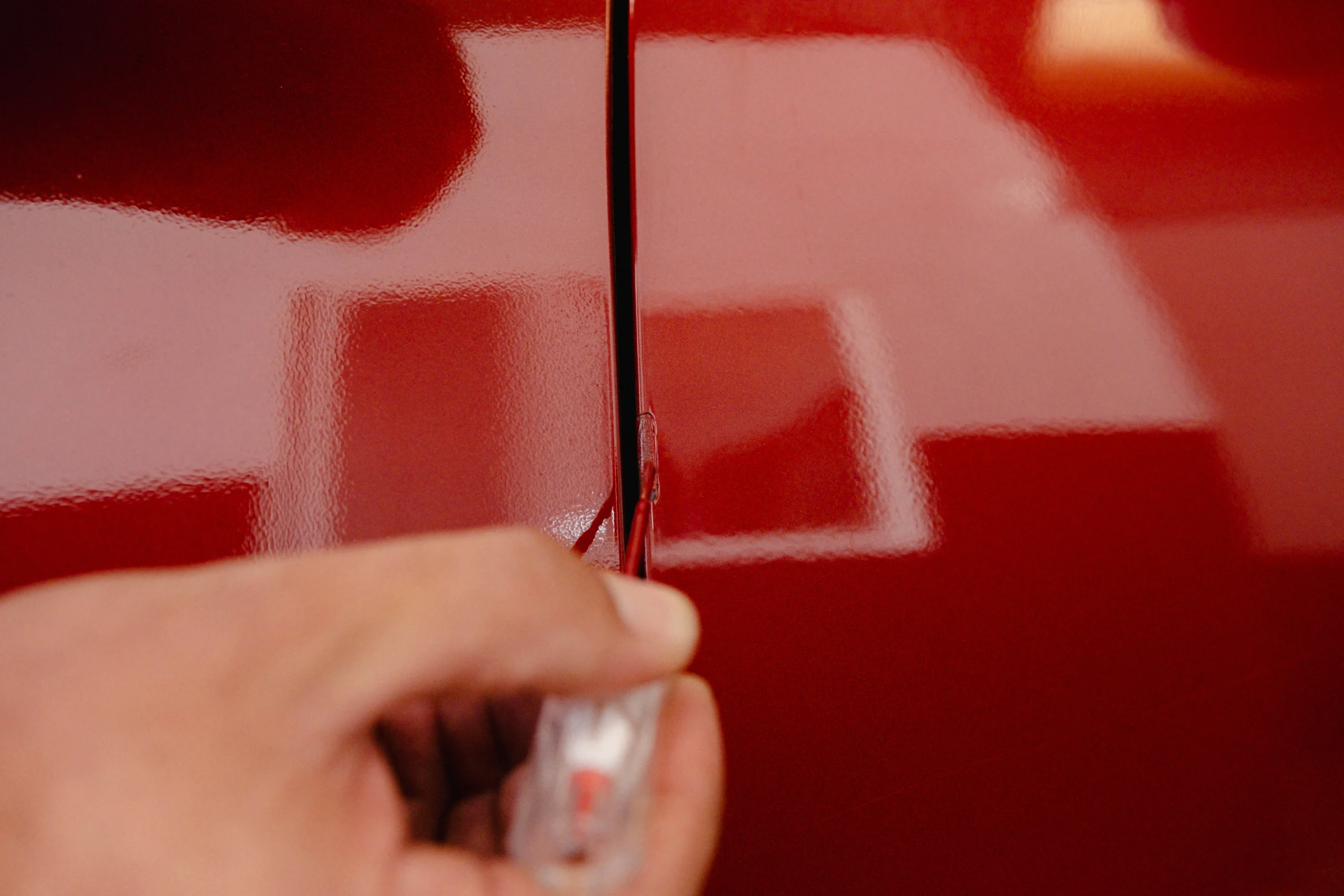Aplicando pintura de retoque sobre la carrocería del coche